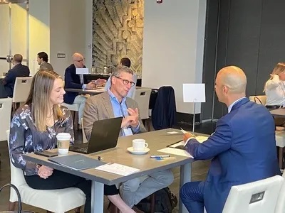 Three individuals discussing on a table 